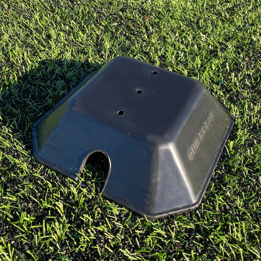 Base Weight set of 2 for KICKSTER, SPOT and agility poles: one black QUICKPLAY base weight on artificial grass, close up from above.