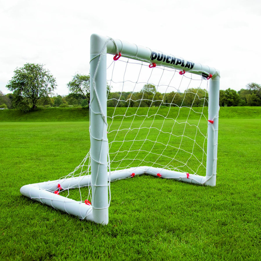 Q-FOLD Mini Football Goal 90 x 75 cm on a grass field, seen from a front corner.