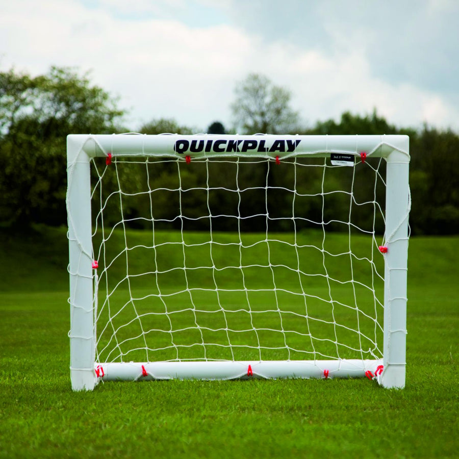 Q-FOLD Mini Football Goal 90 x 75 cm from the front on grass, with QUICKPLAY on the white crossbar.