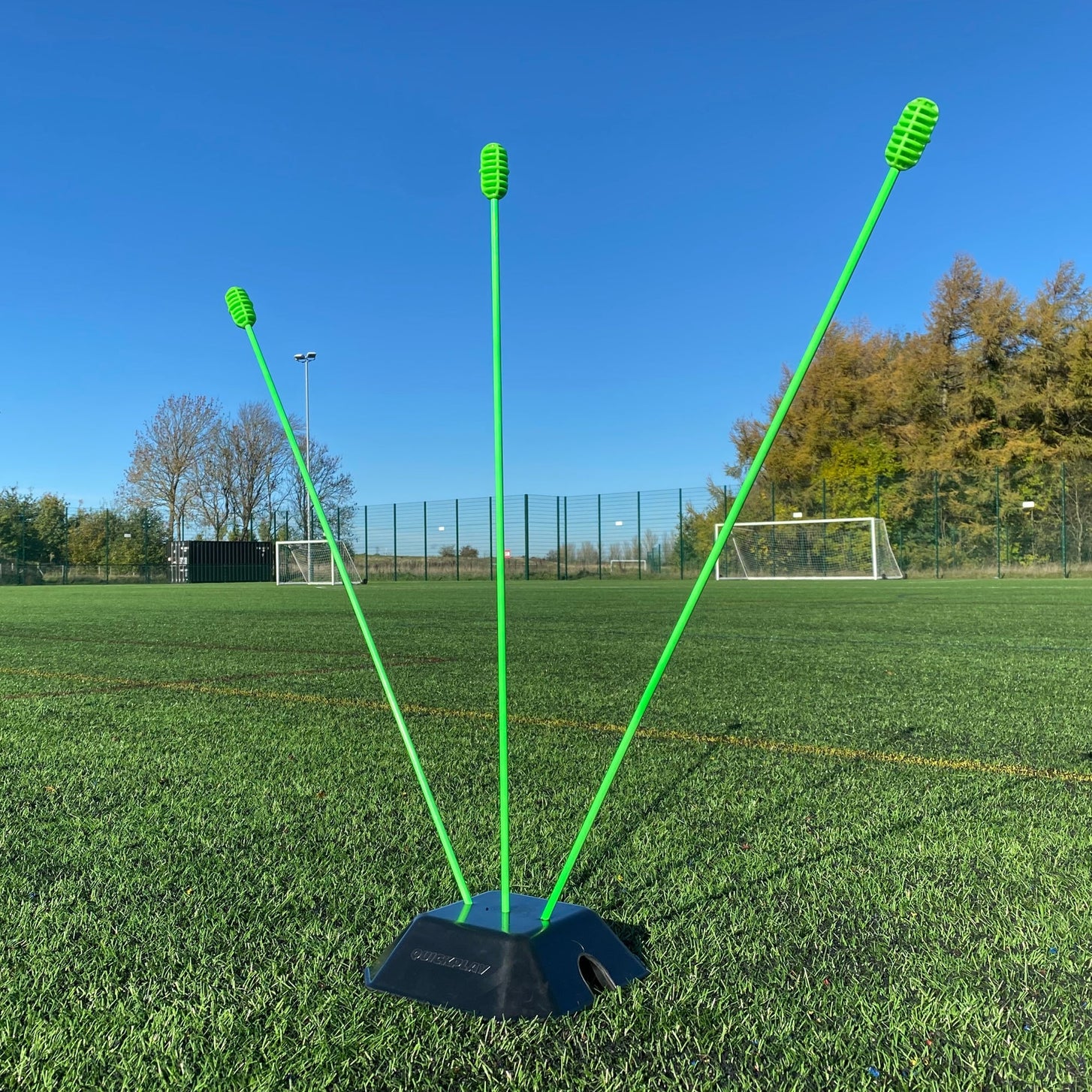 Base Weight set of 2 for KICKSTER, SPOT and agility poles: one base weight holding three green poles at different angles on a pitch.