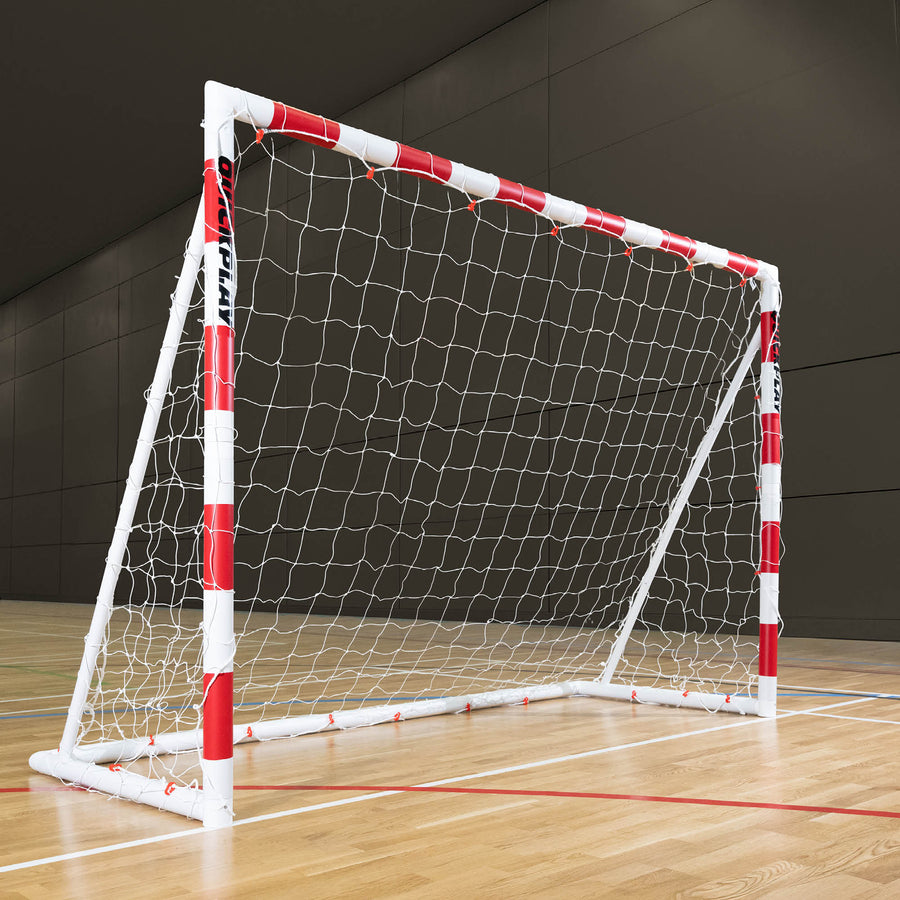 Q-FOLD Folding Handball Goal 300 x 200 cm with red and white striped posts and a white net, on a wooden sports hall floor.