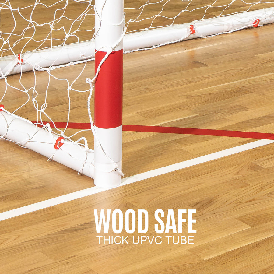 Q-FOLD Handball Goal 300 x 200 cm close-up of a red and white post on a wooden floor, with the text "Wood safe, thick uPVC tube".