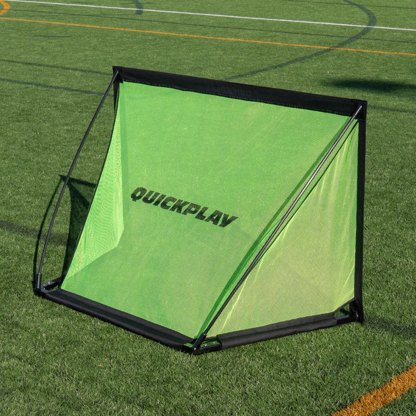 KICKSTER PRO 120 x 75 cm goal on artificial grass seen from above the front, with QUICKPLAY on the green net.