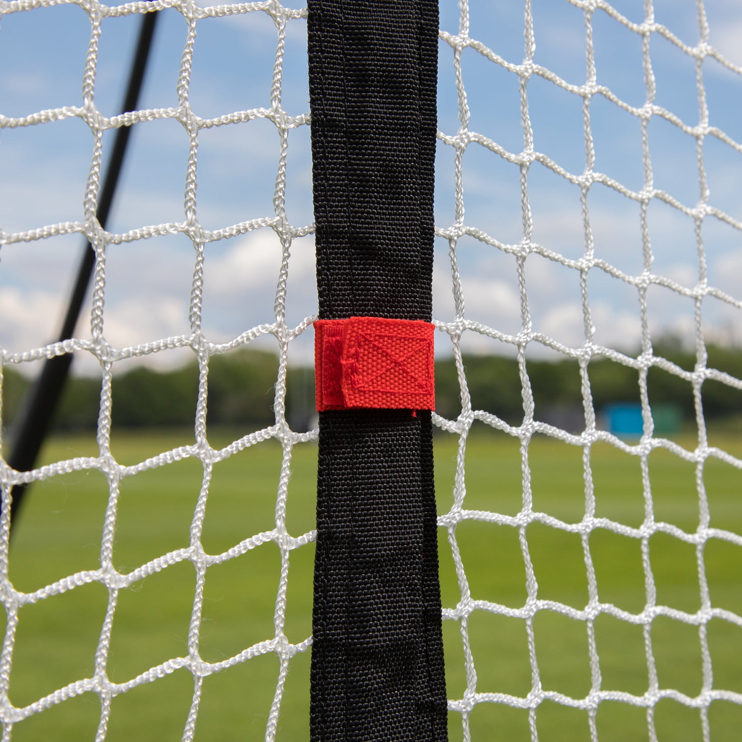 Extender Net 240 x 270 cm for MEGA NET close up: black strap with a red tab on the white netting.
