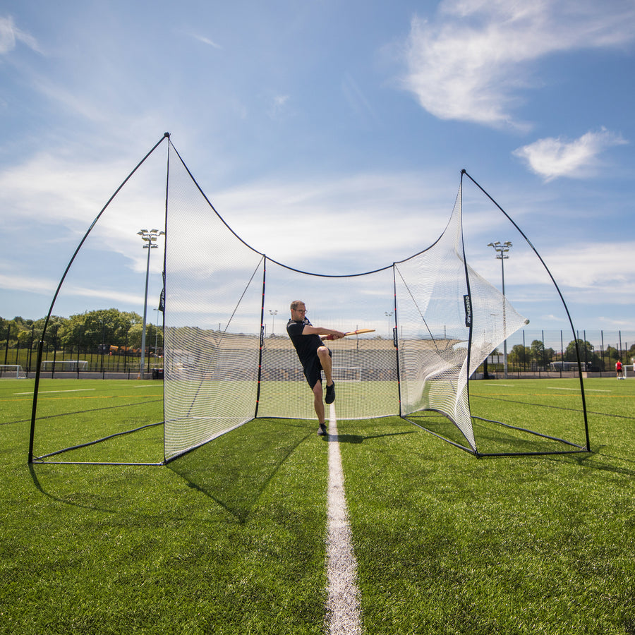Man swinging a wooden bat inside a U-shaped setup of two MEGA NETs with the Extender Net 240 x 270 cm in the middle.