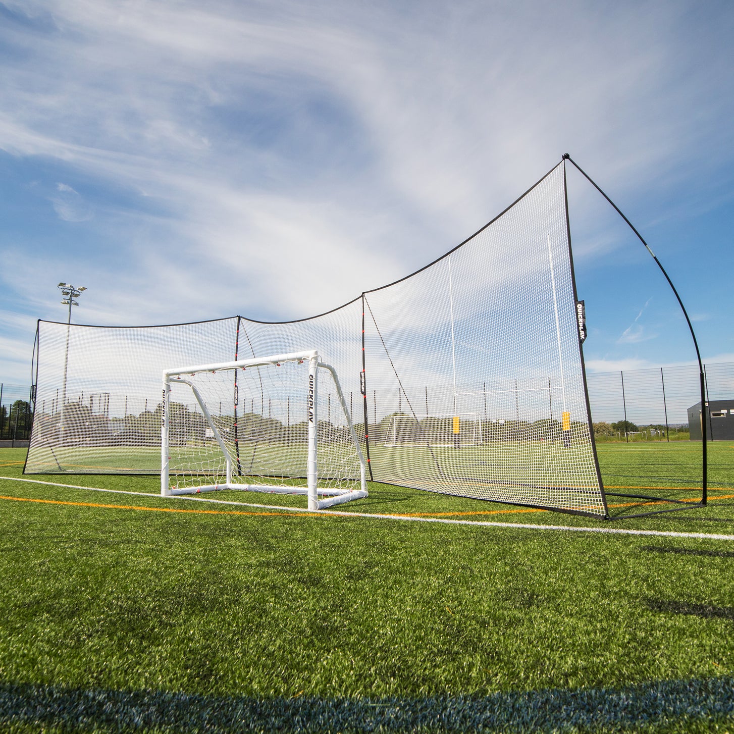Extender Net 240 x 270 cm linking two MEGA NETs in a ball-stop line behind a white QUICKPLAY goal on an artificial pitch.