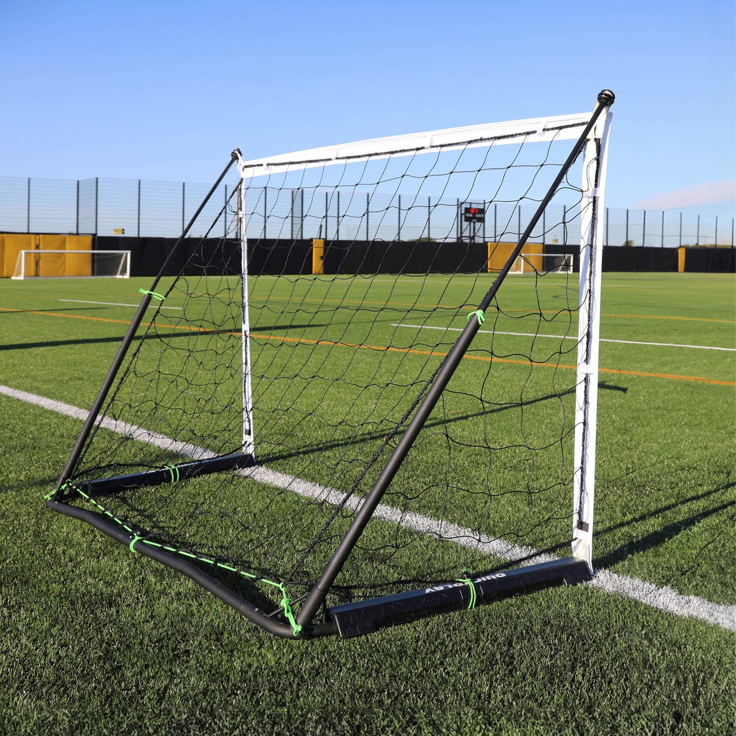 KICKSTER Elite 150 x 100 cm seen from a rear corner on an artificial pitch, showing the black frame and green ties.