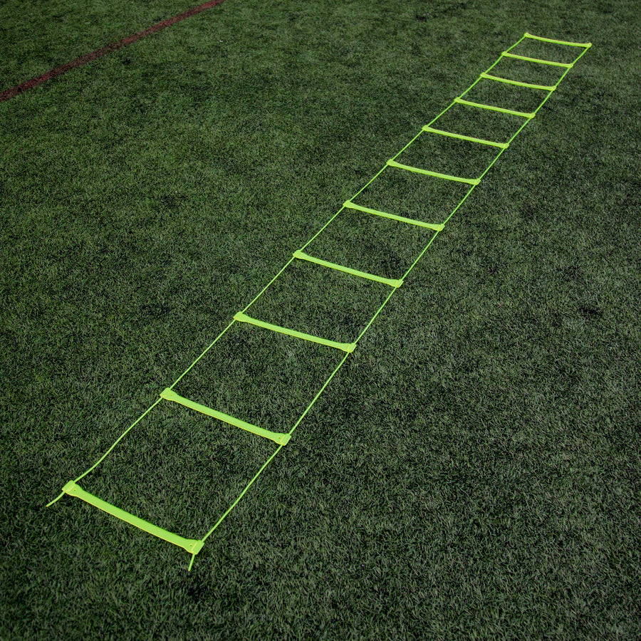 Yellow Agility Ladder laid out flat at full length on an artificial pitch, seen from one end.