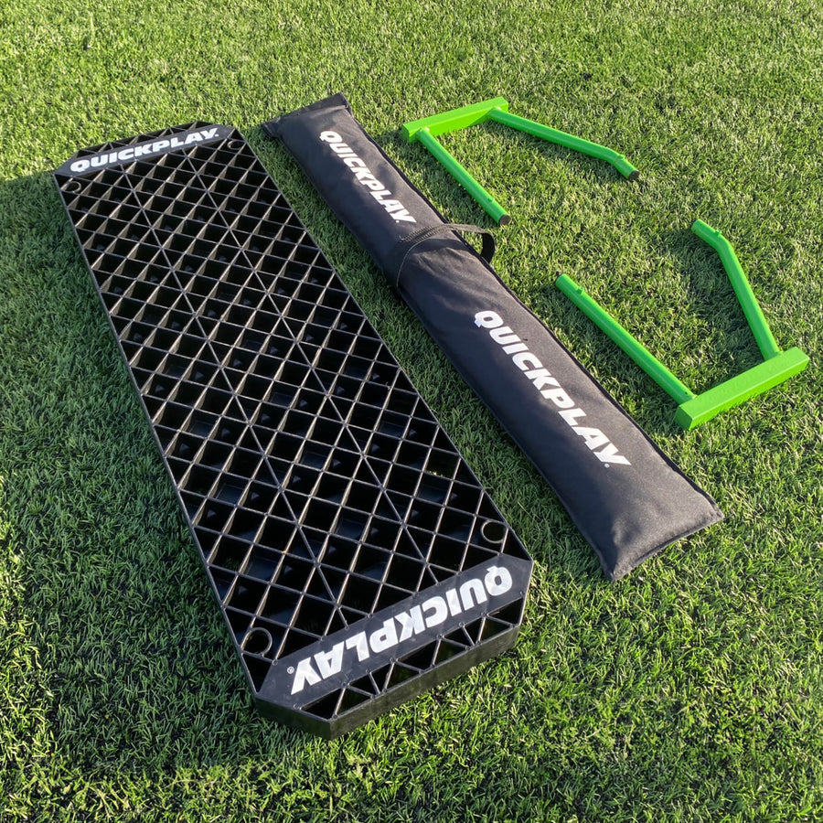 REPLAY Station XL parts laid out on grass: black board, black QUICKPLAY bag and two green frames.