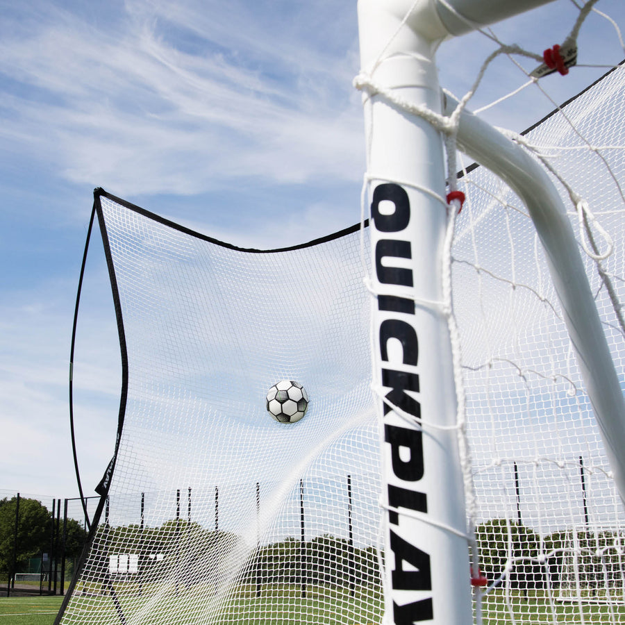 MEGA NET 370 x 270 cm ball-stop catching a football behind a white QUICKPLAY goal post, seen from low down.