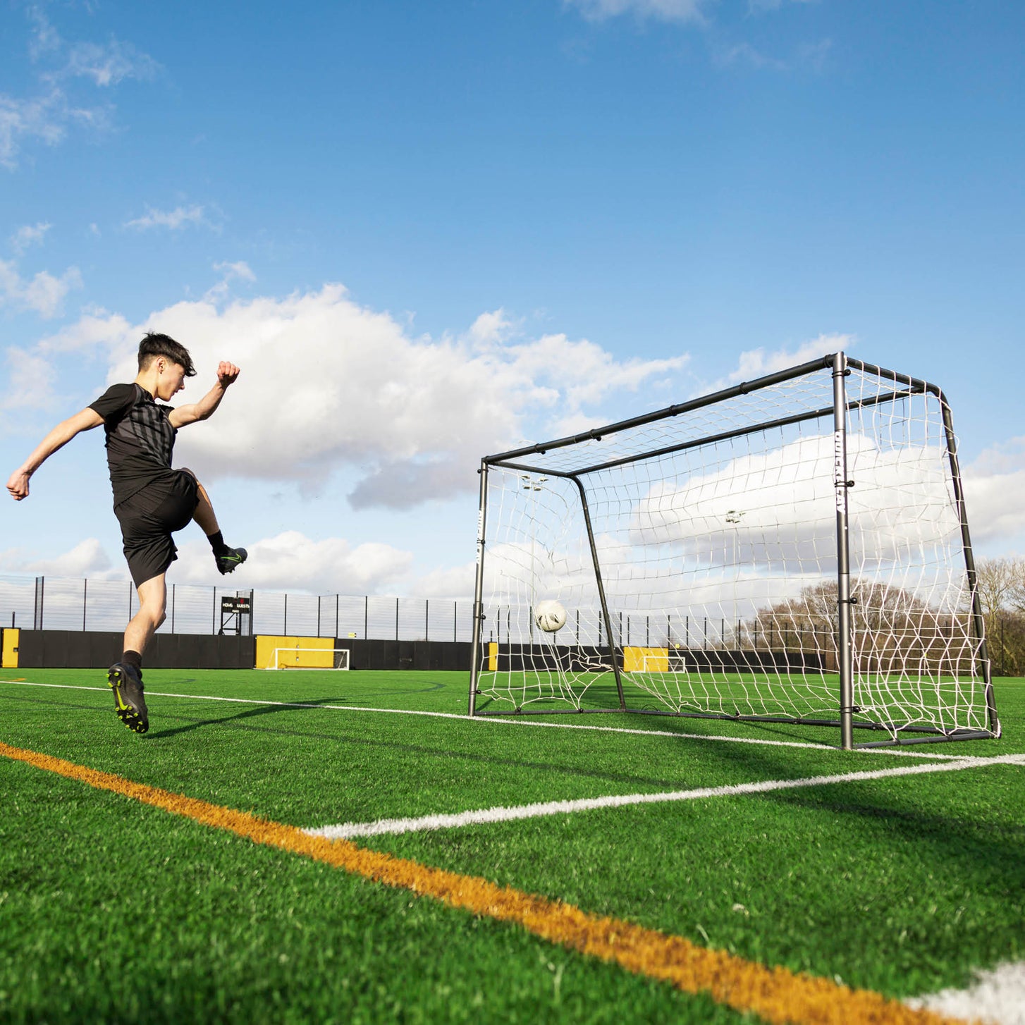 Player shooting at the GS Series Futsal Goal 300 x 200 cm on an artificial pitch, with the ball flying into the net.