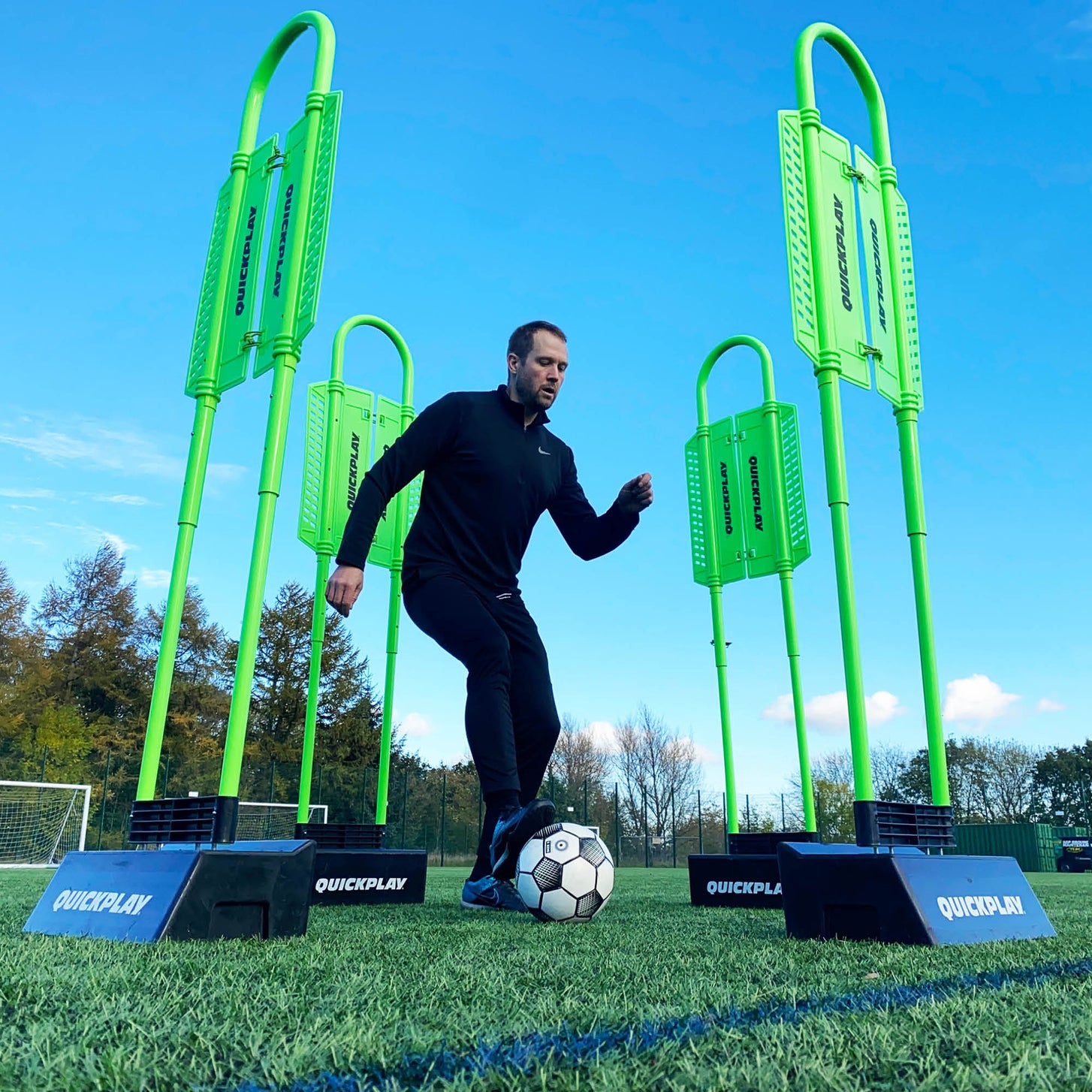 REPLAY Defender & Block System from a low angle: player dribbling a ball between four green mannequins in black bases.