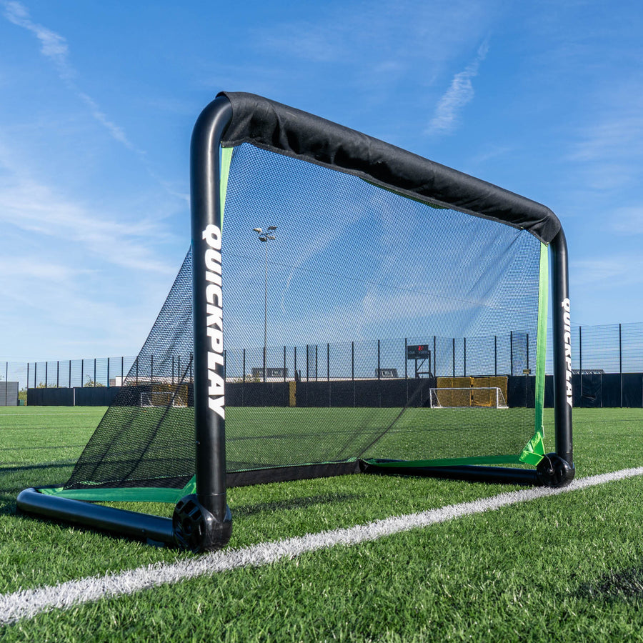 RHINO Football Goal 120 x 75 cm with a thick black frame and black net, standing on the line of an artificial pitch.