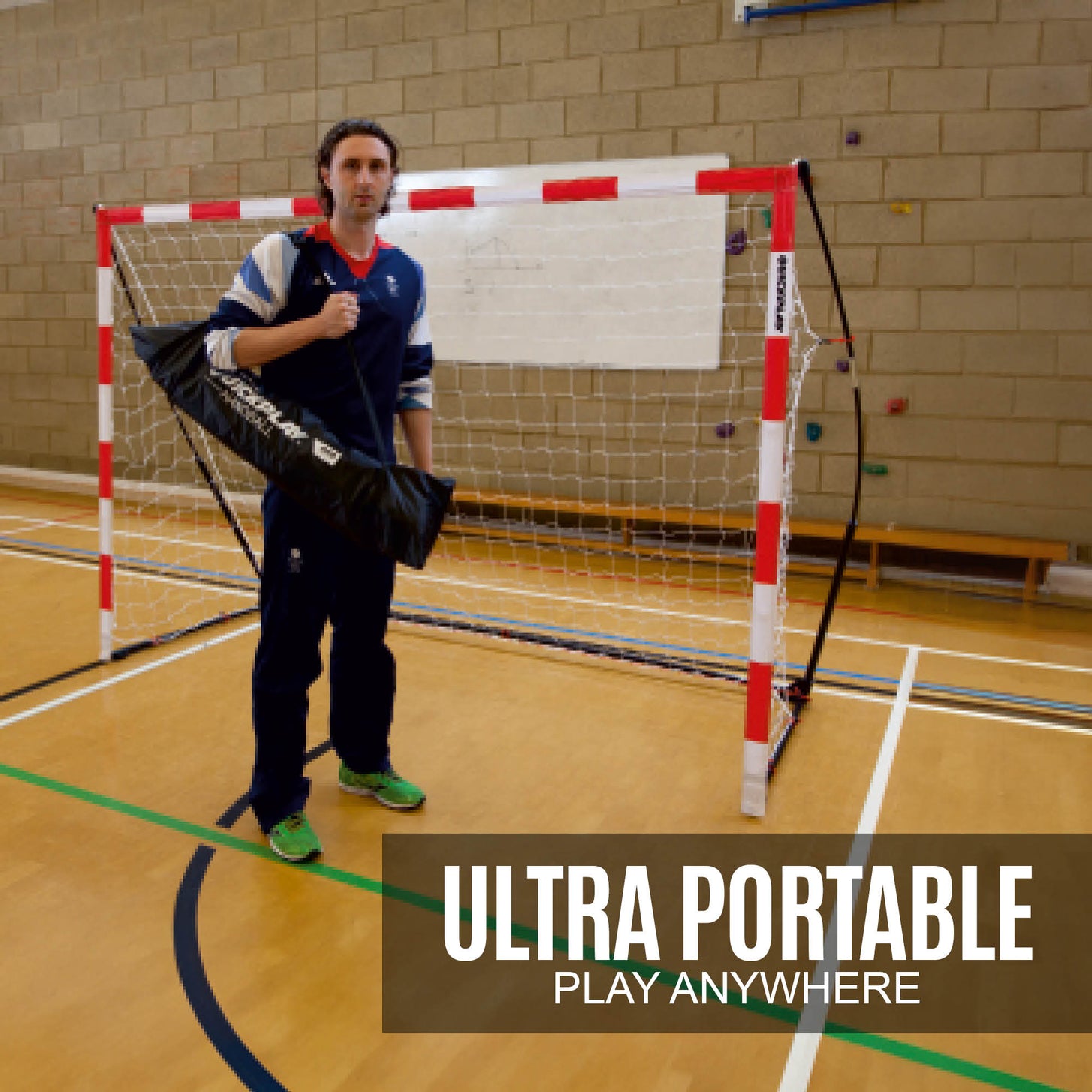 Man holding a black QUICKPLAY bag in front of the Portable Handball Goal Junior 240 x 170 cm in a sports hall, text: ultra portable.
