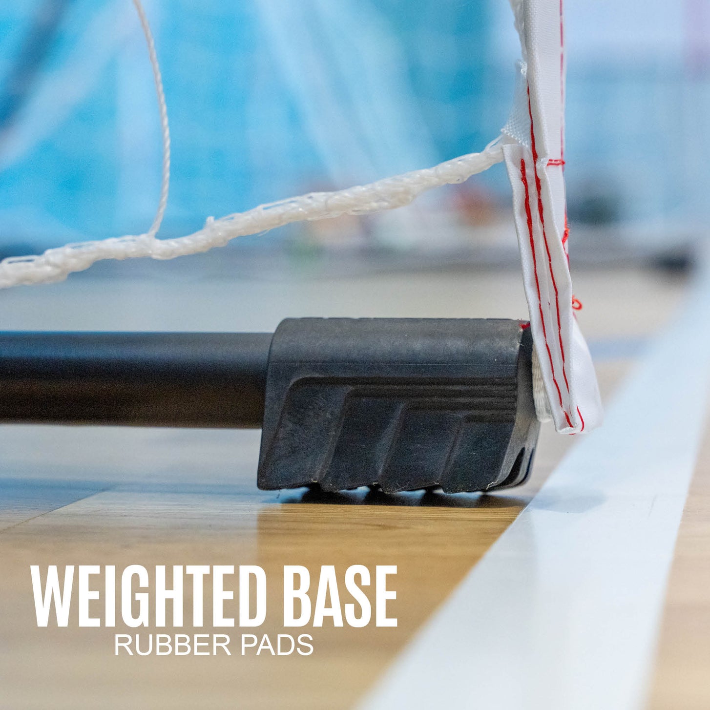 Portable Handball Goal Junior 240 x 170 cm base close up on a hall floor, with the text: weighted base, rubber pads.